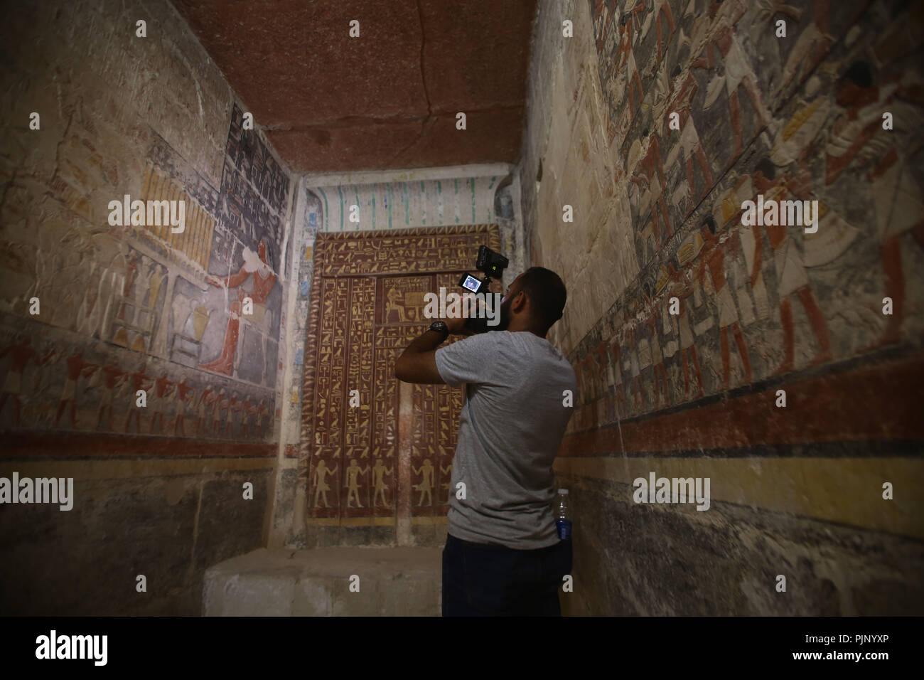 Giza in Egitto. 8 Sep, 2018. Un uomo prende le foto all'interno di una tomba a Giza, vicino a Il Cairo, Egitto, Sett. 8, 2018. Egitto inaugurato sabato un antico regno tomba di un uomo chiamato Mehu che era un ministro durante la fine della sesta dinastia. Credito: Ahmed Gomaa/Xinhua/Alamy Live News Foto Stock