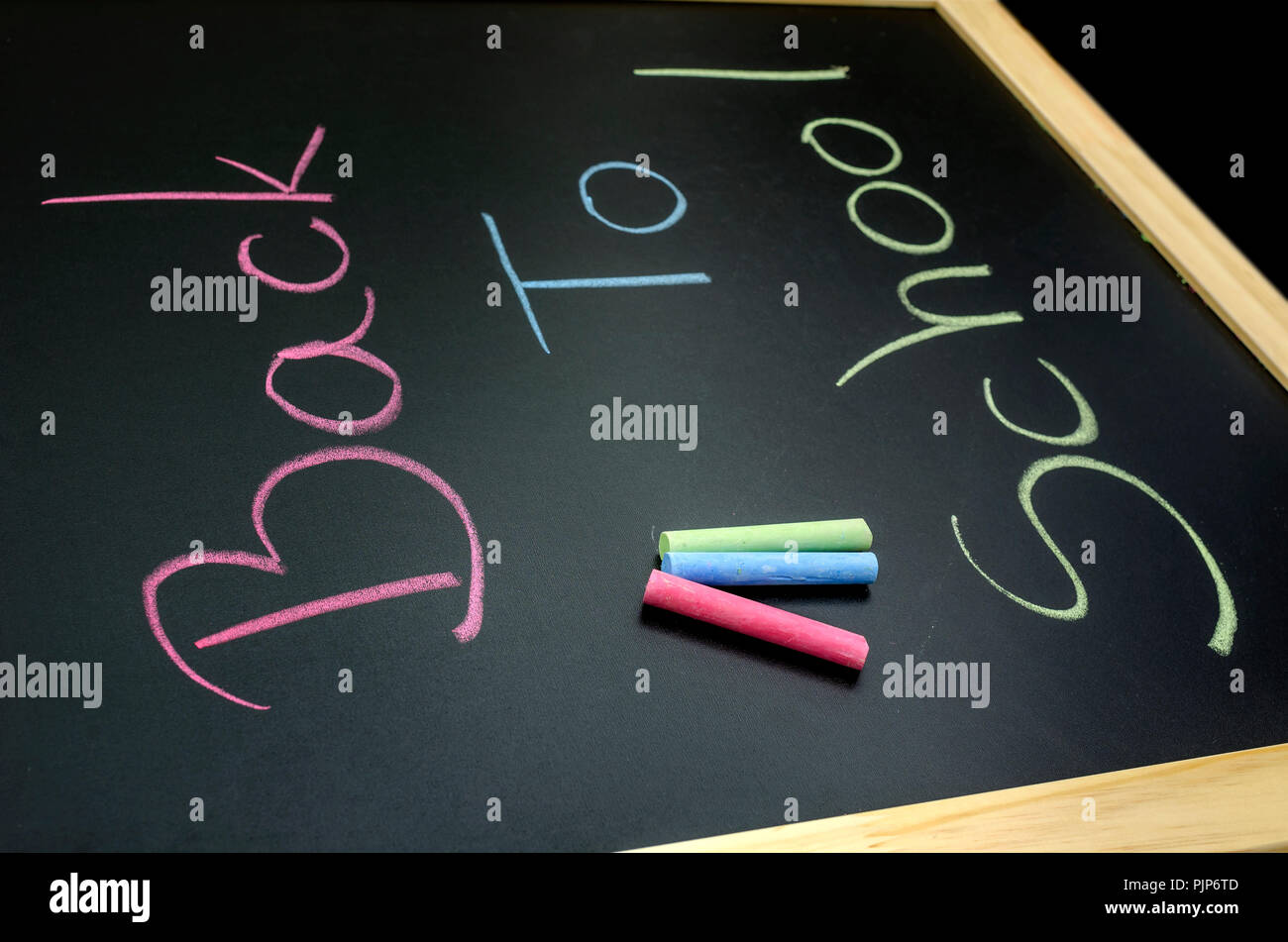 Vista superiore del testo si torna a scuola scritto in colori sulla lavagna. Foto Stock