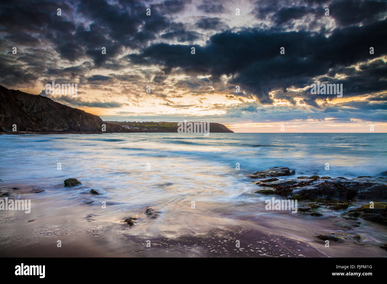 Tramonto sulla spiaggia di Tresaith in Ceredigion, Galles, guardando verso Aberporth. Foto Stock