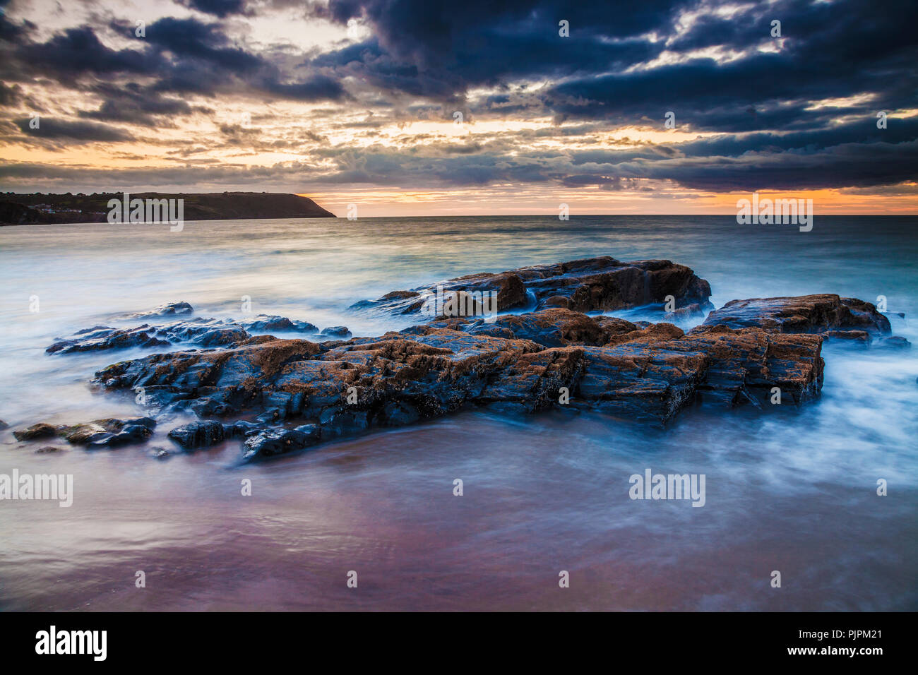 Tramonto sulla spiaggia di Tresaith in Ceredigion, Galles, guardando verso Aberporth. Foto Stock