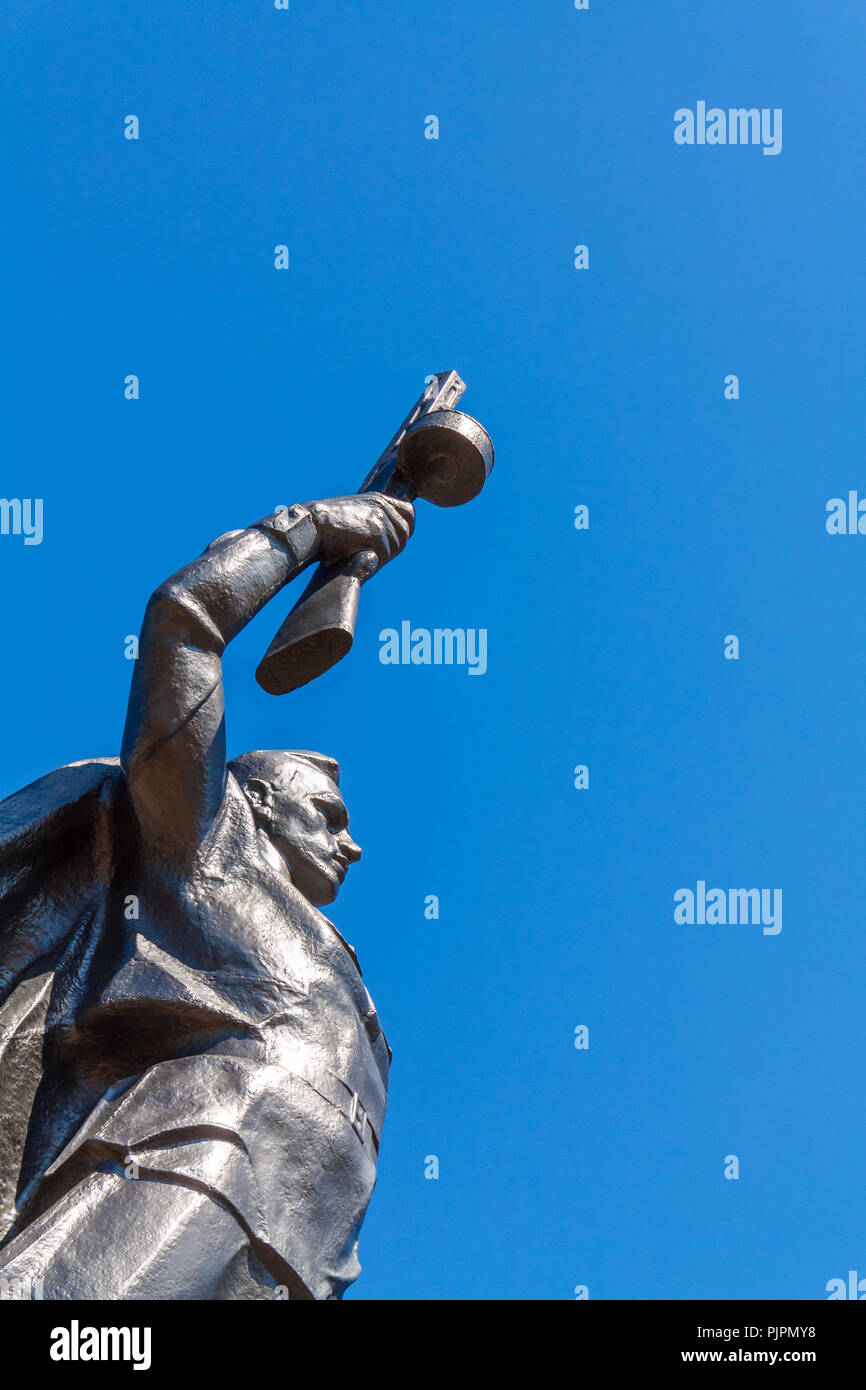 Monumento a un soldato sovietico con un mitragliatore in mano di un partecipante nella seconda guerra mondiale contro un cielo blu. Foto Stock