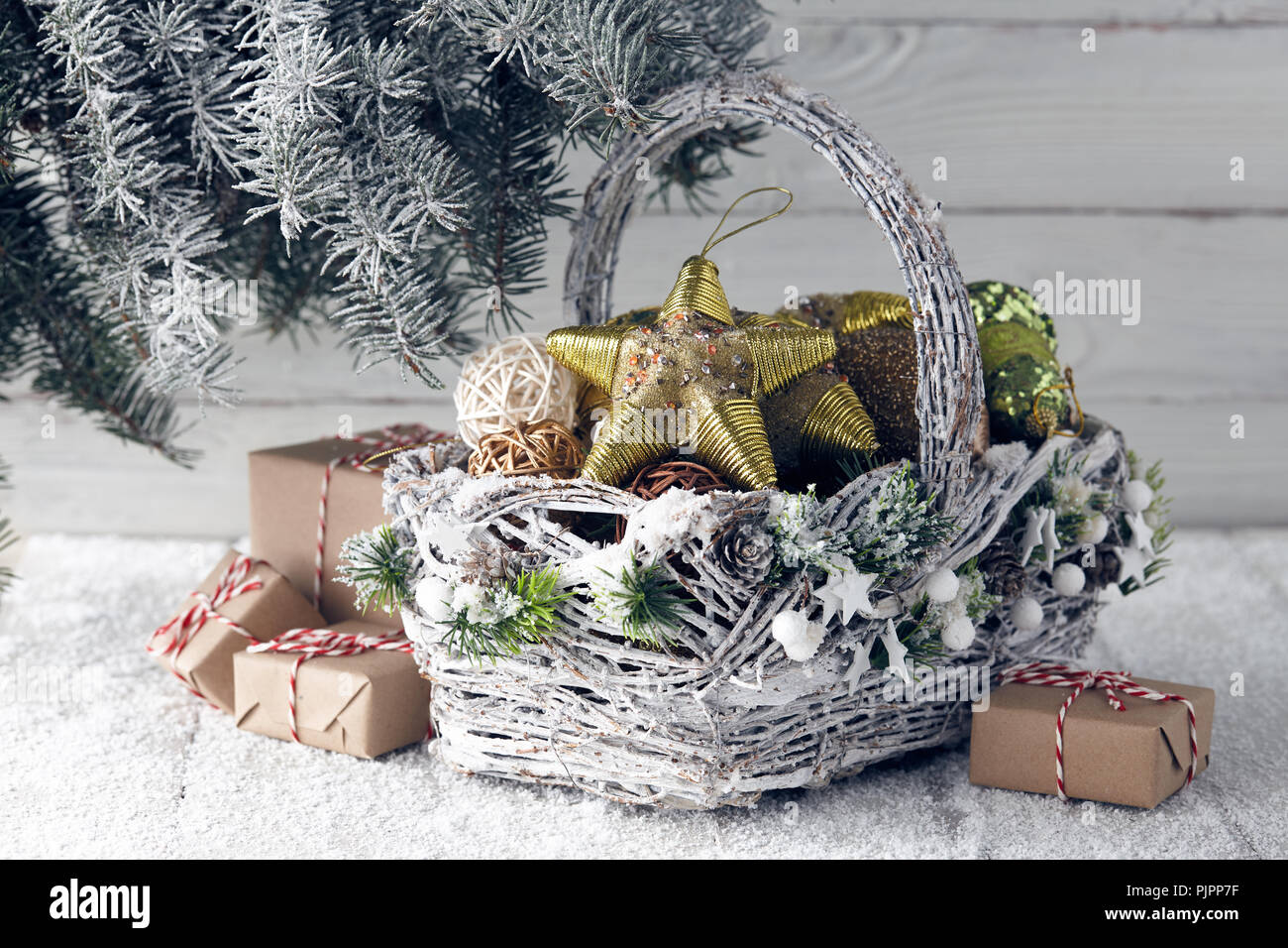 Cesto in Vimini con regalo di Natale scatole, giocattoli e decorazioni di  vacanza sotto snowy abete Foto stock - Alamy