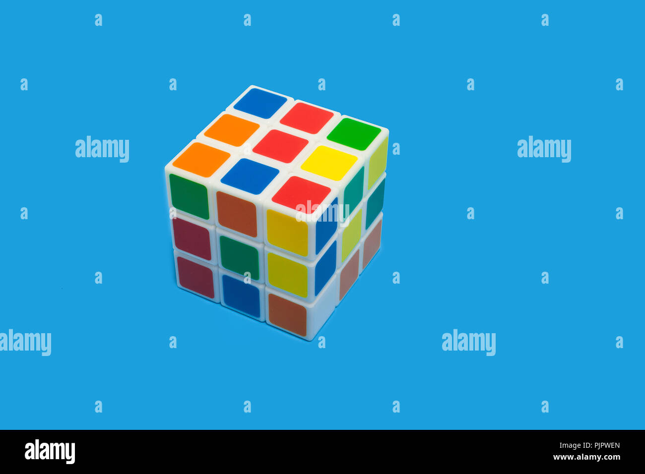 In plastica colorata rubiks cube giacenti su uno sfondo blu isolato. concetto di sviluppo di giocattoli Foto Stock