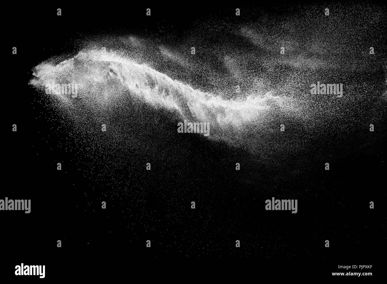 Congelare il movimento di bianco le particelle di polvere su sfondo nero Foto Stock
