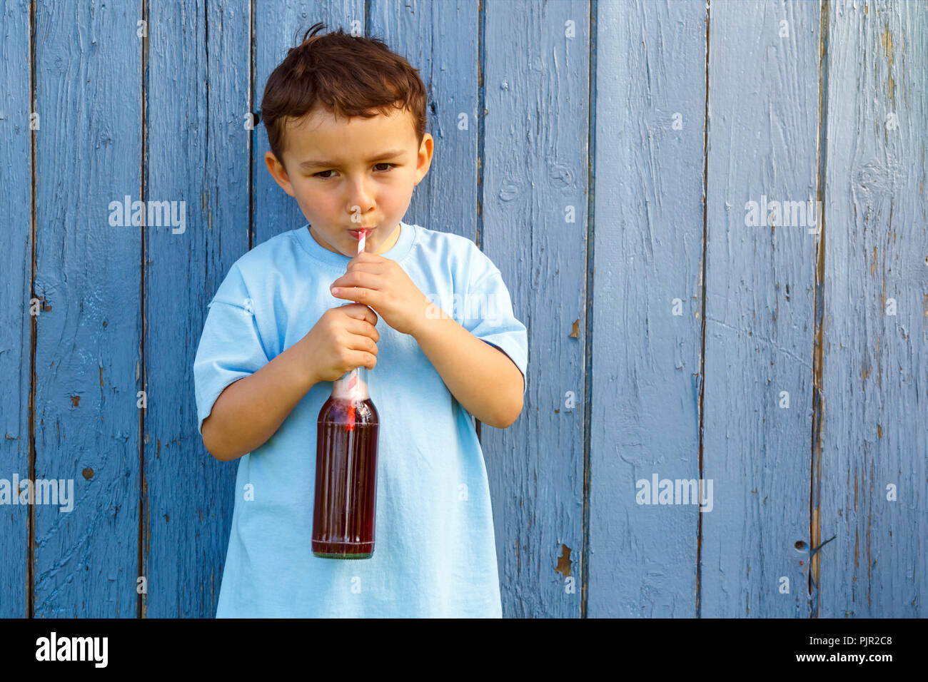 Bambino kid ragazzino bere limonata drink all'aperto all'aperto al di fuori di bottiglia Foto Stock