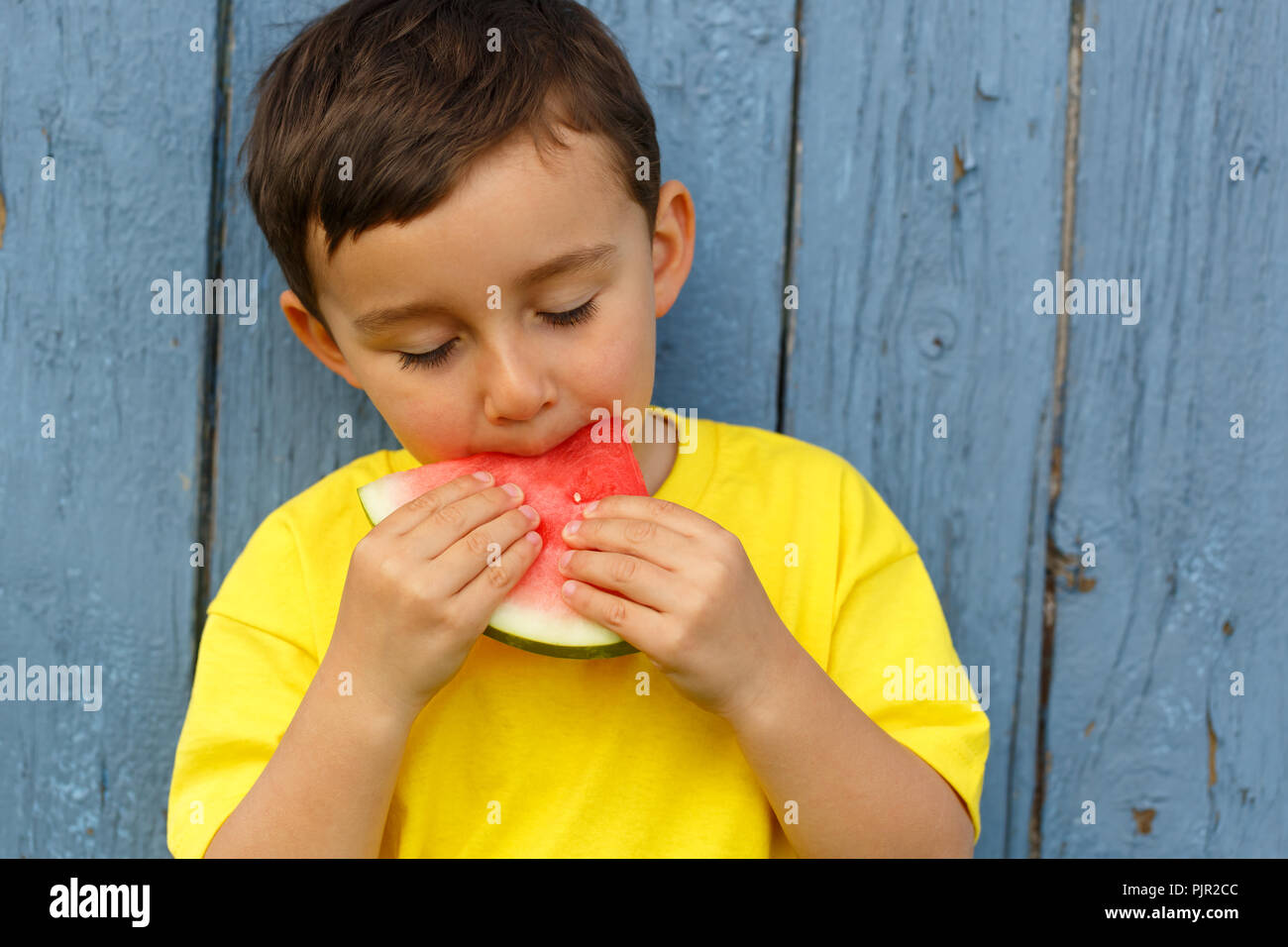 Bambino kid ragazzino mangiando anguria estate copyspace copia spazio all'aperto all'aperto al di fuori di mordere Foto Stock