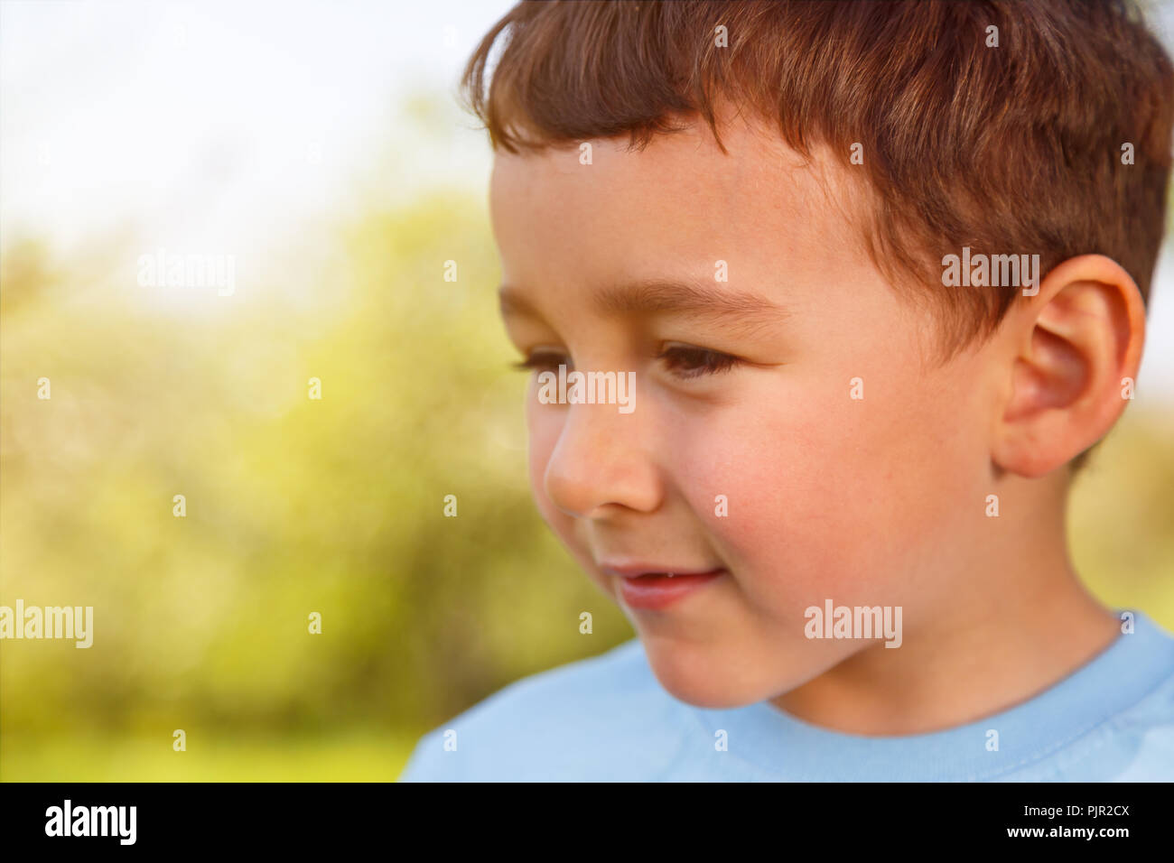 Bambino kid ragazzino ritratto outdoor copyspace guardando al lato esterno al di fuori di primavera la natura Foto Stock