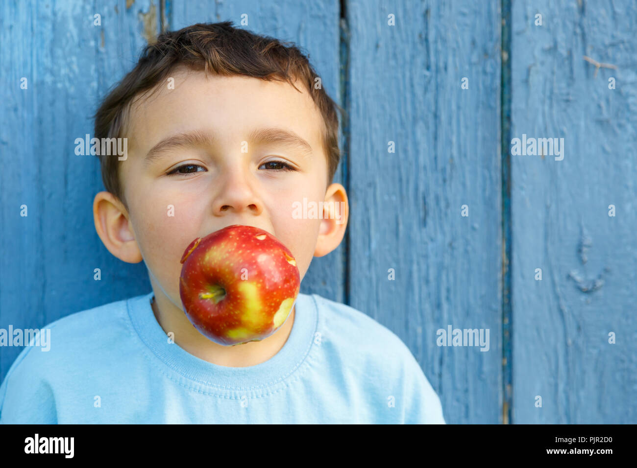 Bambino kid little boy apple copyspace di frutta copia spazio all'aperto all'aperto al di fuori di mordere Foto Stock