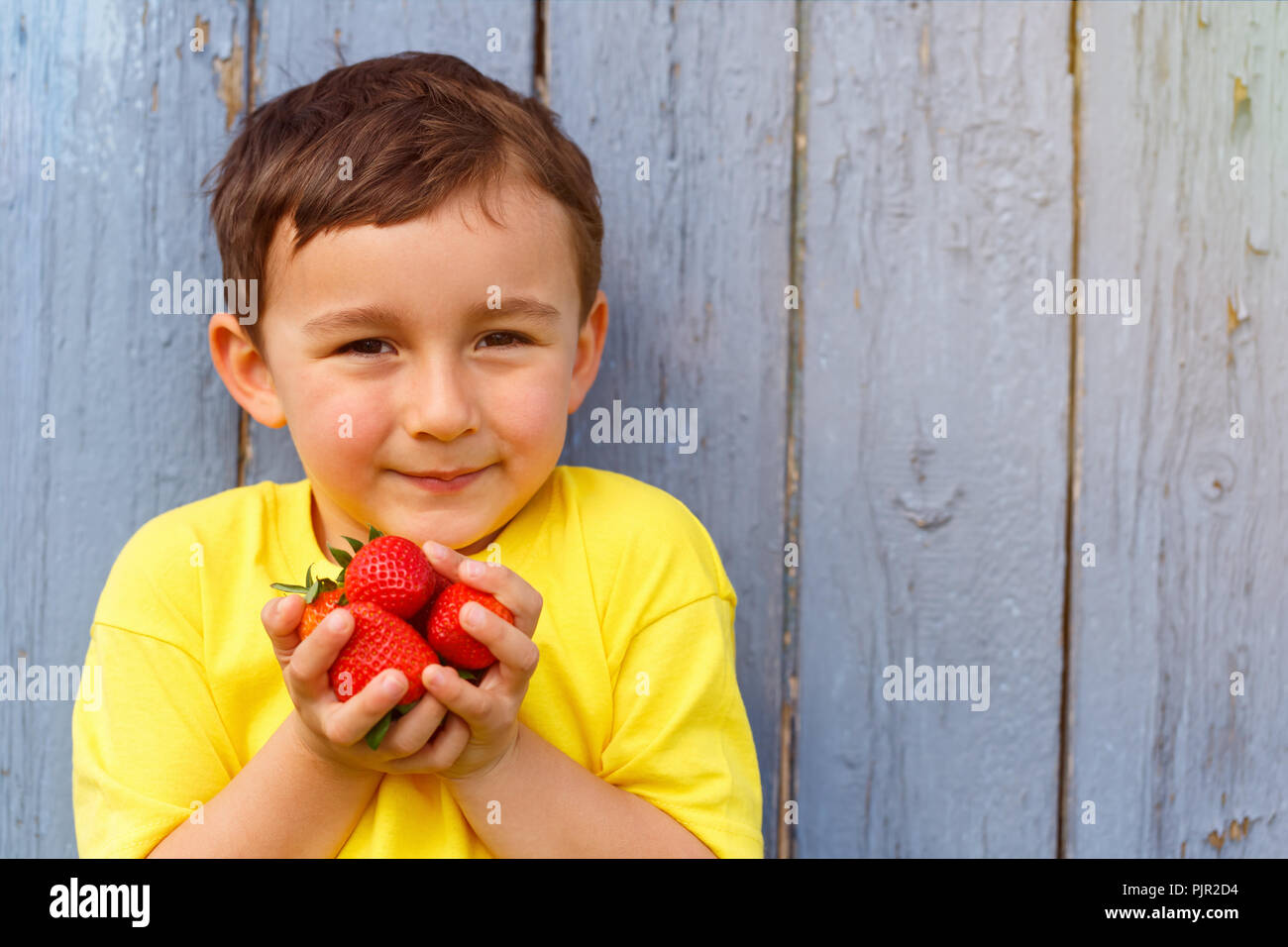 Bambino kid little boy fragole estate fragole copyspace copia spazio all'aperto all'aperto al di fuori la molla Foto Stock