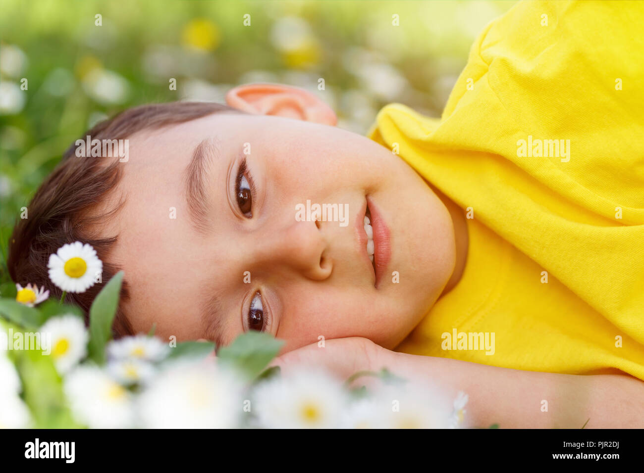 Bambino kid primavera fiore fiori di prato ragazzino sognando il giorno all'aperto all'aperto al di fuori del campo della natura Foto Stock