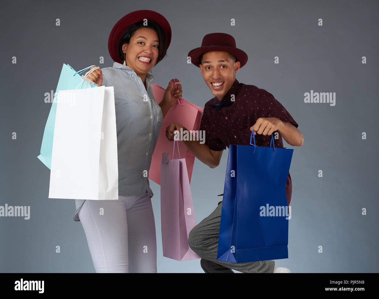 Funny jumping shopping giovane isolato su sfondo per studio Foto Stock