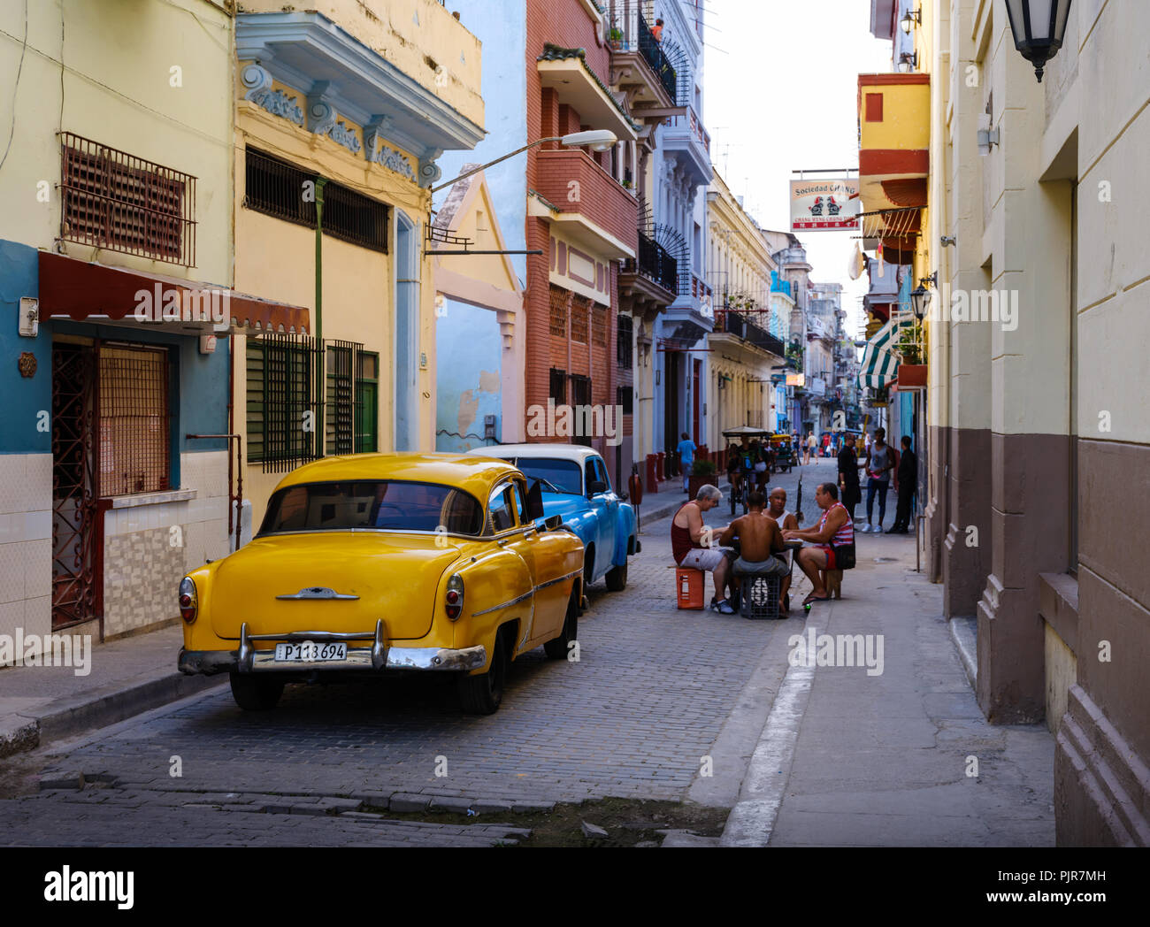 L'Avana, Cuba - CIRCA NEL MAGGIO 2017: vecchie automobili classiche nelle strade di l'Avana con persone che giocano a Domino. Foto Stock
