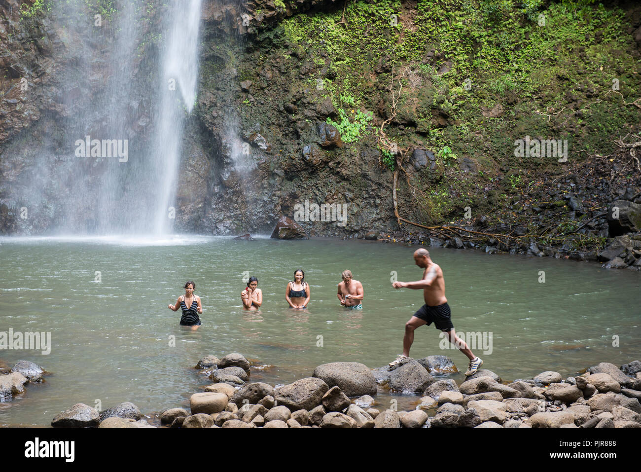 Intrepid bagnanti in corrispondenza di una cascata rock pool, Kauai Foto Stock