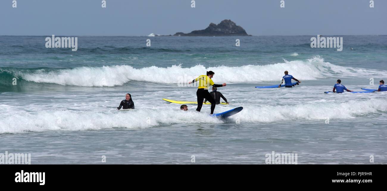 Persone provenienti da una scuola di surf a esercitarsi in Sennen Cove,Cornwall,l'Inghilterra,UK Foto Stock
