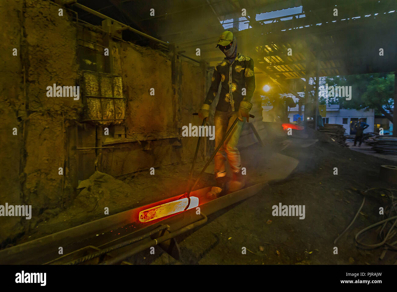 Indian i lavoratori industriali lavorando duro in situazione difficile in fonderia. Foto Stock