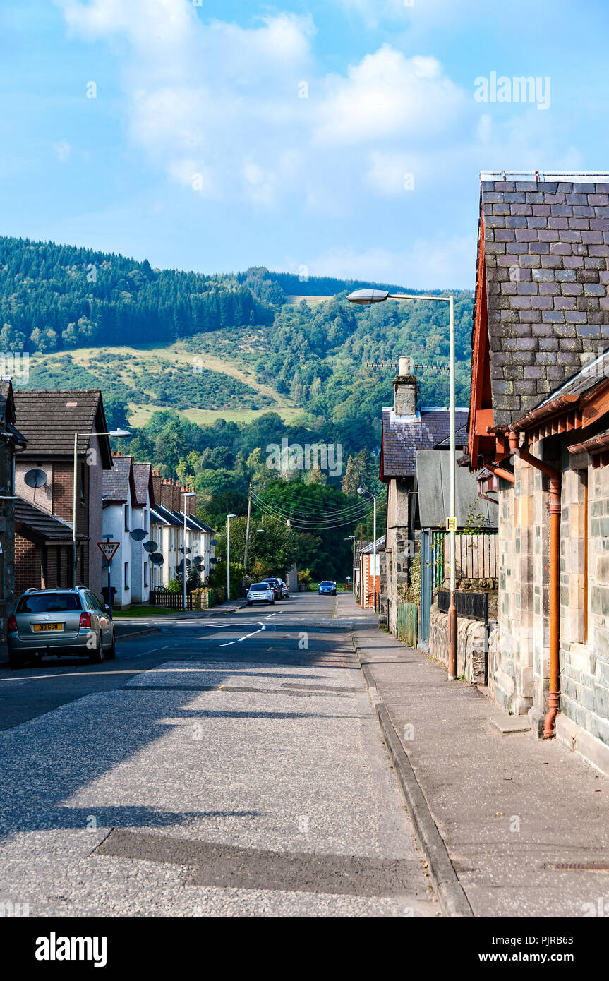 La magnifica vista di una collina boschiva che salgono dal fondo della strada in cui le case di visualizzare un abbondanza di piatti di televisione. Foto Stock