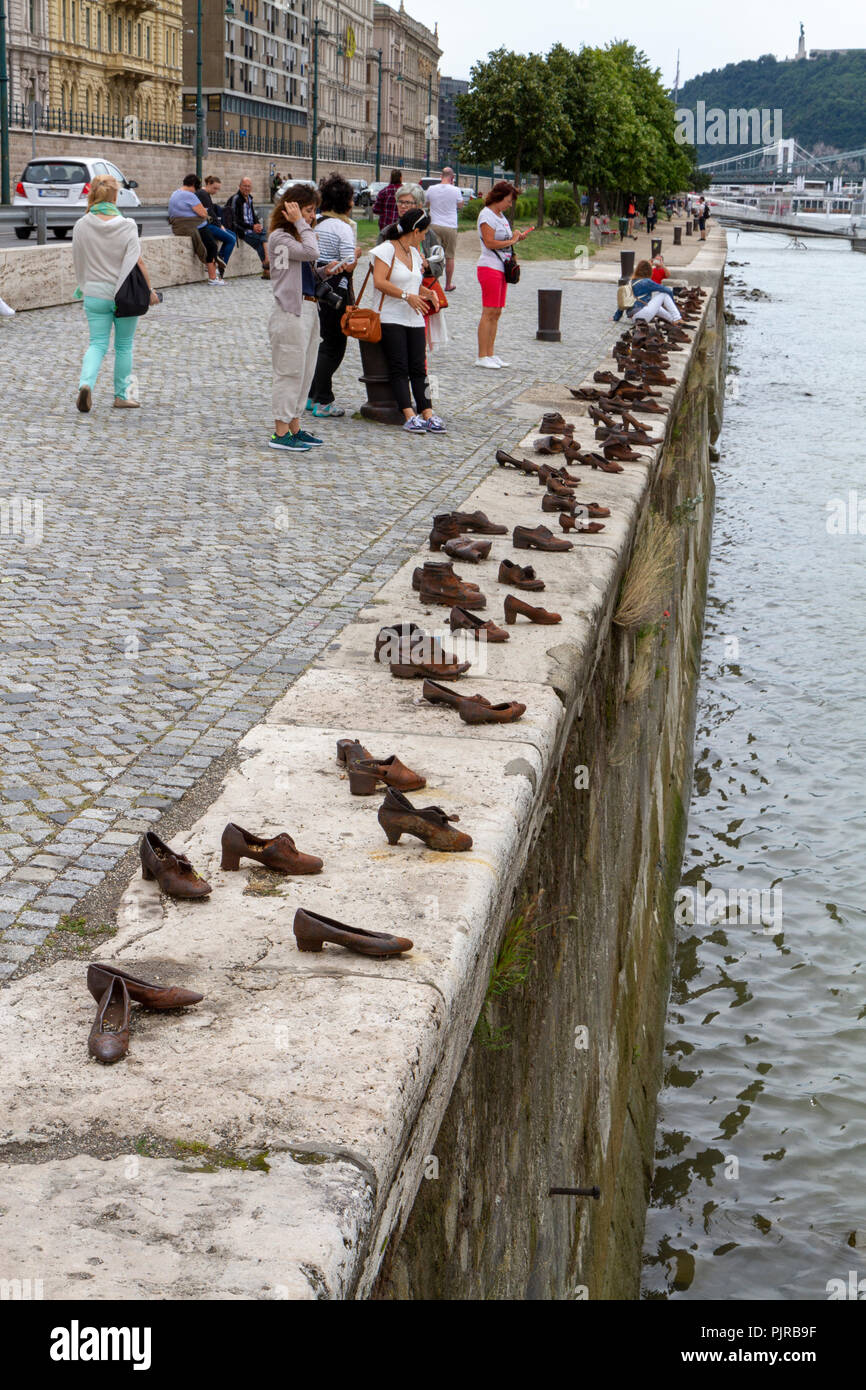 I turisti che visitano le scarpe sulla sponda del Danubio Memorial, concepito da può Togay scolpito da Gyula Pauer, il fiume Danubio, Budapest, Ungheria. Foto Stock