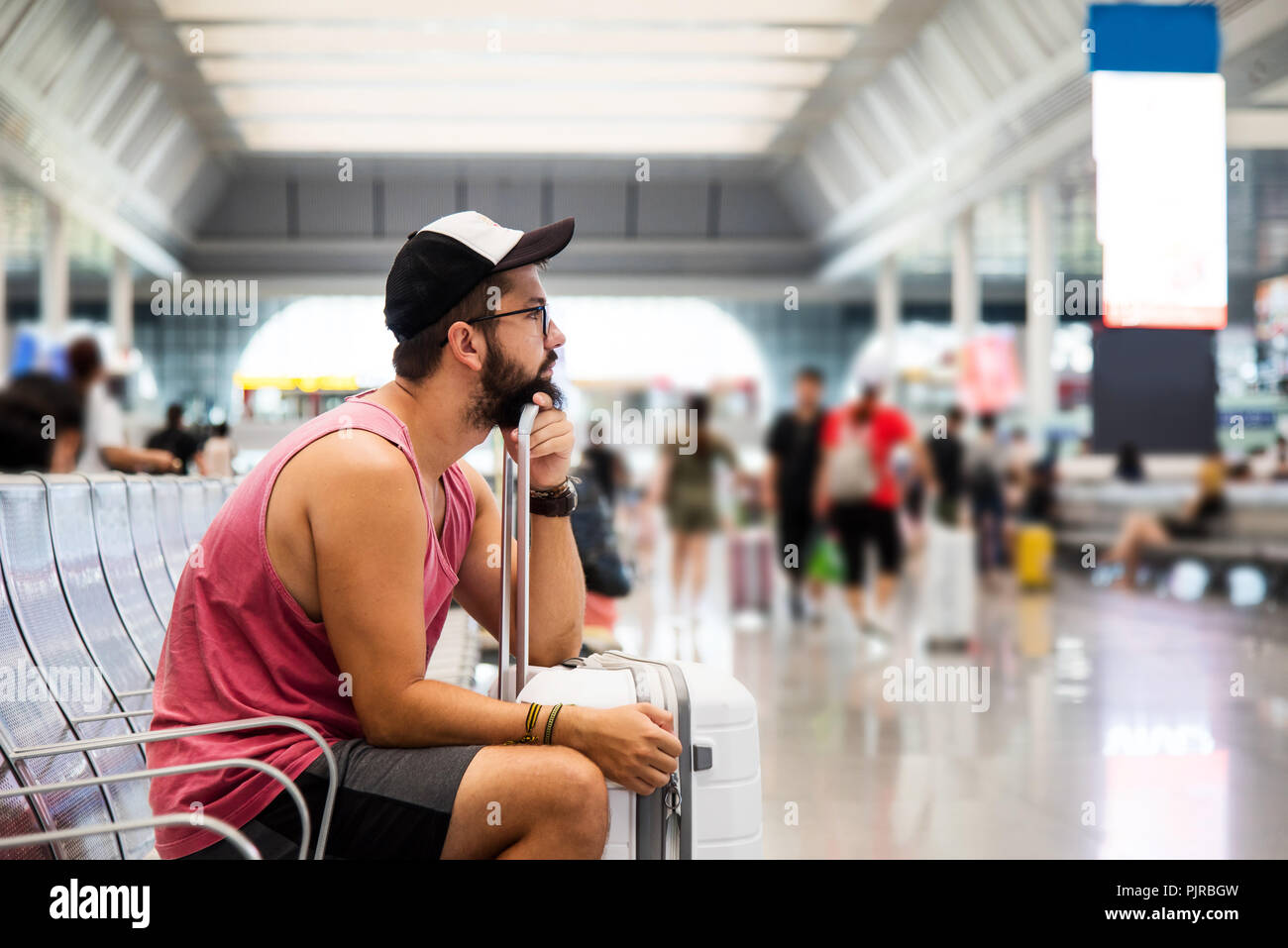 Uomo in attesa del trasporto nella stazione ferroviaria Foto Stock