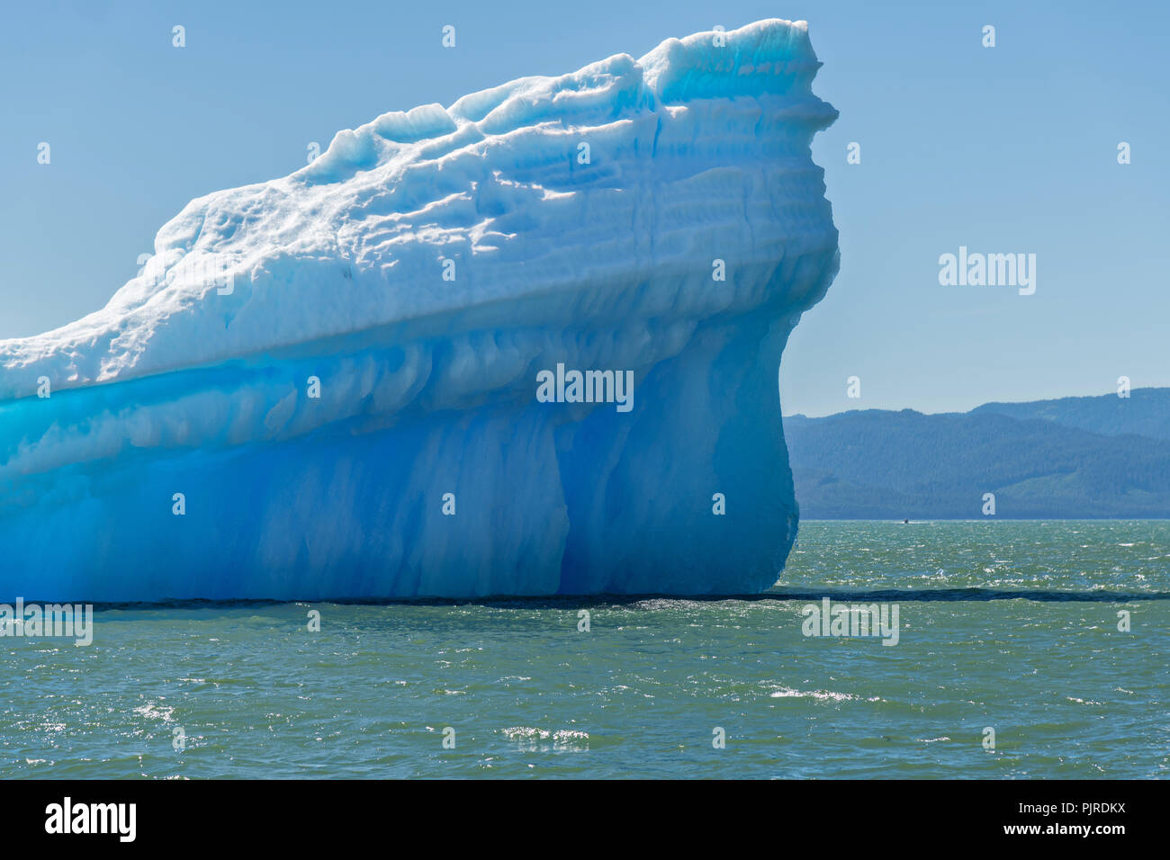 Un gigante di ghiaccio berg galleggianti in Frederick Sound vicino alla bocca del lecont Bay in Isola di San Pietroburgo, Alaska. L iceberg partorito fuori il vicino ghiacciaio LeConte che è la più meridionale la tidewater ghiacciaio dell'emisfero settentrionale. Foto Stock