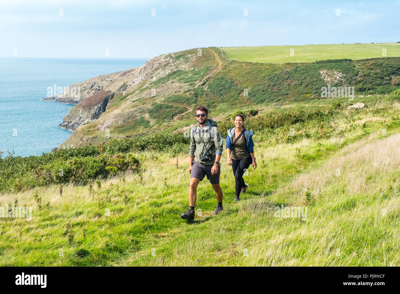 Il Pembrokeshire Coast National Park, il Galles, UK. Matura in loro venti anni camminando sul sentiero costiero vicino a testa Strumbles Foto Stock