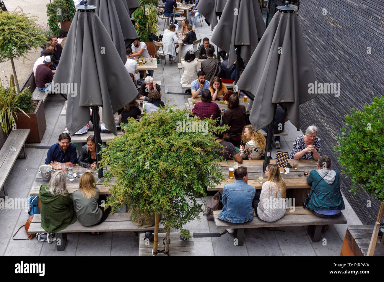 La gente seduta al di fuori del pub Lighterman a King's Cross, Londra England Regno Unito Regno Unito Foto Stock