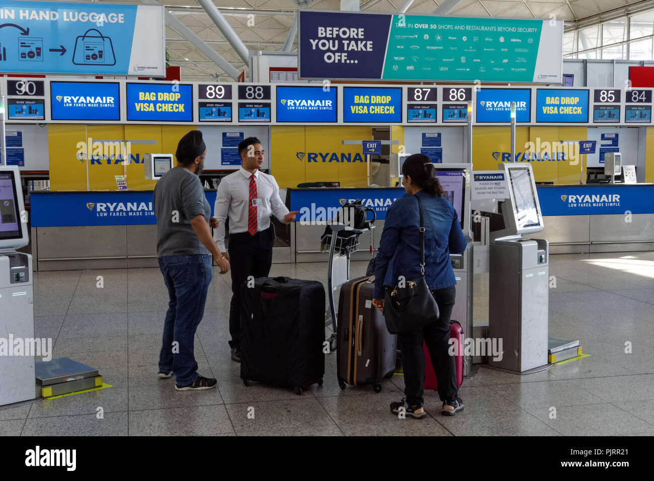 I passeggeri che utilizzano la Ryanair auto bag drop unità all'Aeroporto Stansted di Londra England Regno Unito Regno Unito Foto Stock