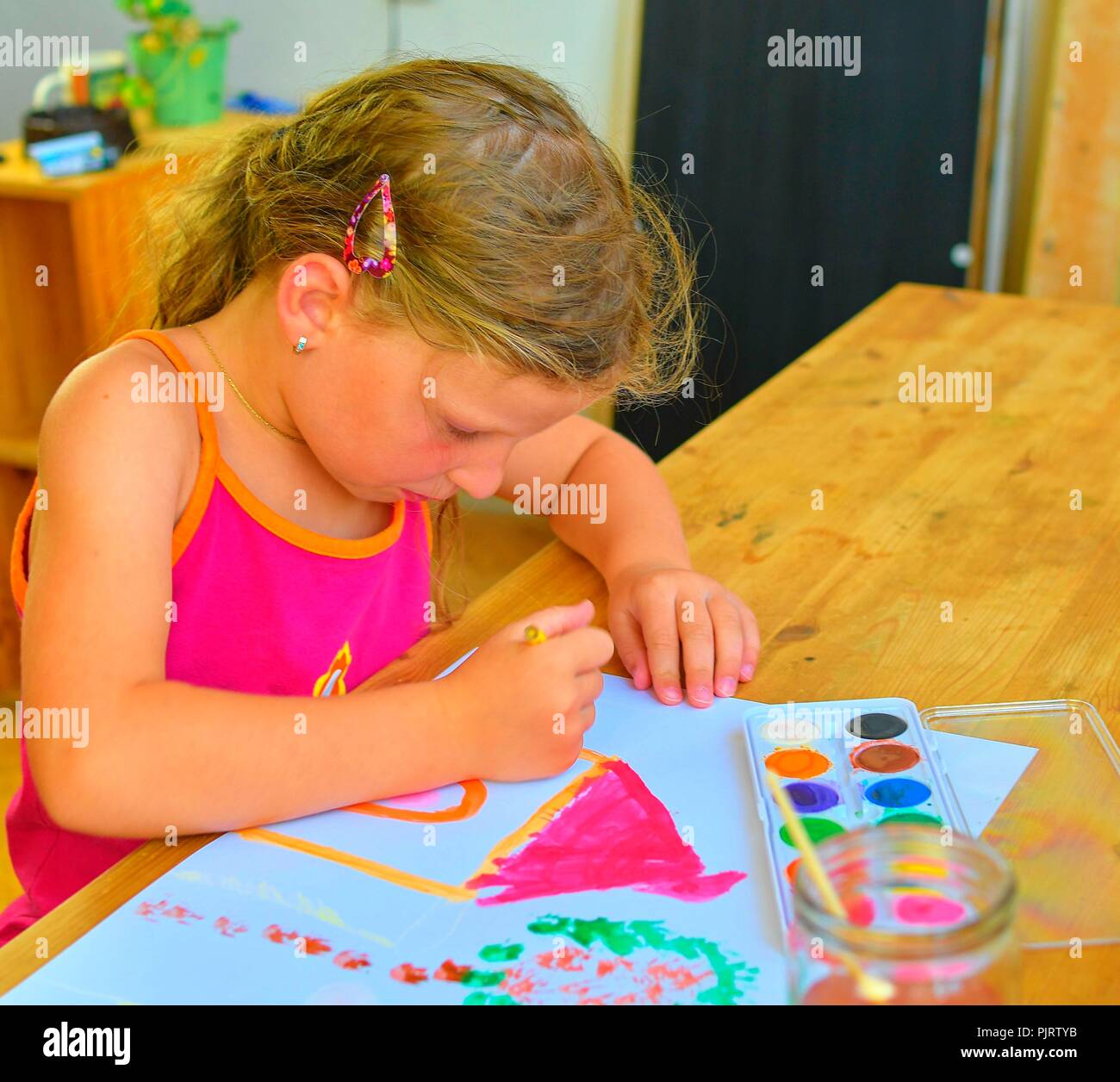 Carino bambina pittura immagine della casa. Ragazza carina pittura con acquarelli. Concetto di mortage. Messa a fuoco selettiva, piccole DOF Foto Stock