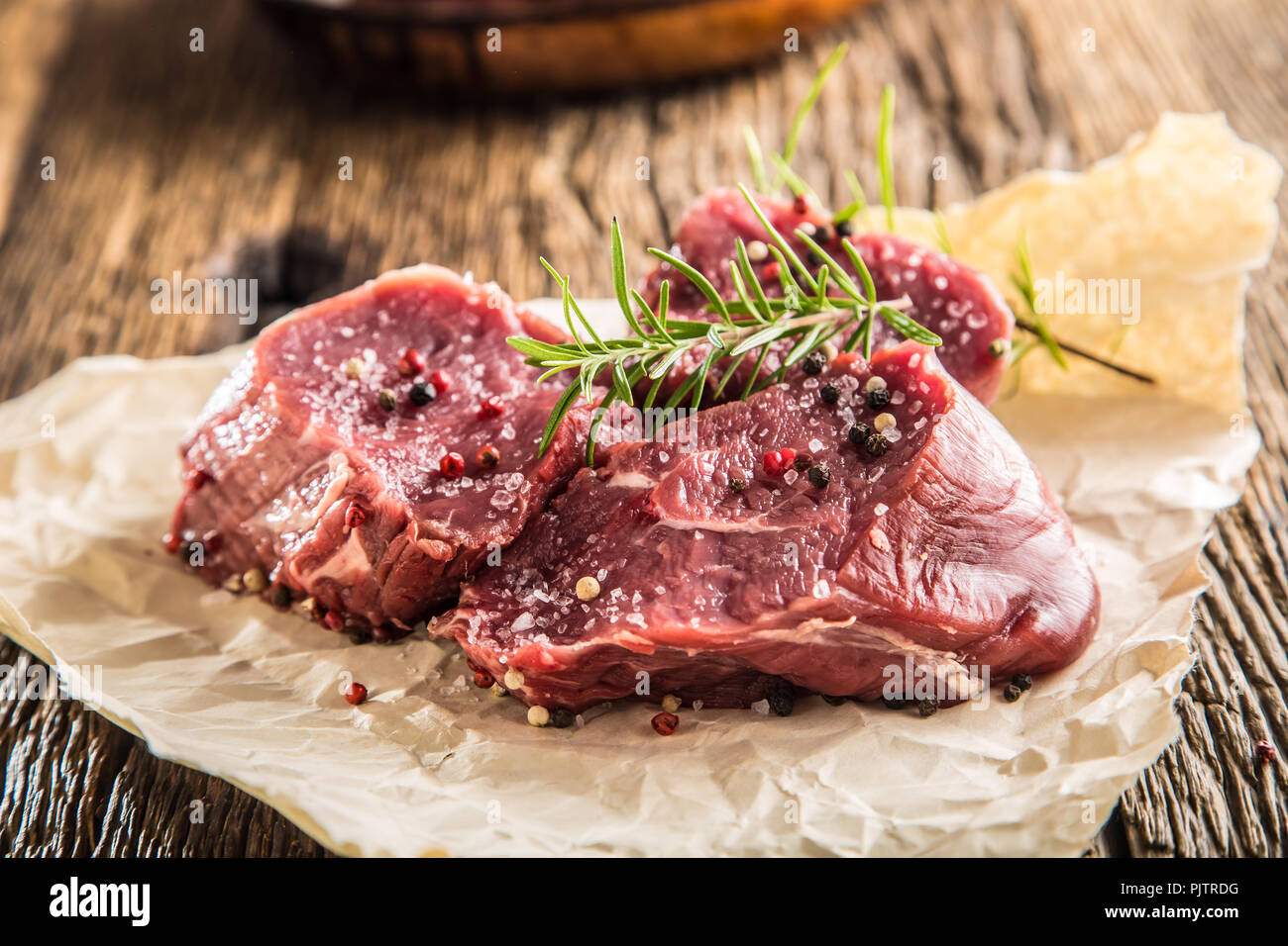 Close-up delle fette di carne di manzo bistecca tenterloin sale pepe e rosmarino. Foto Stock