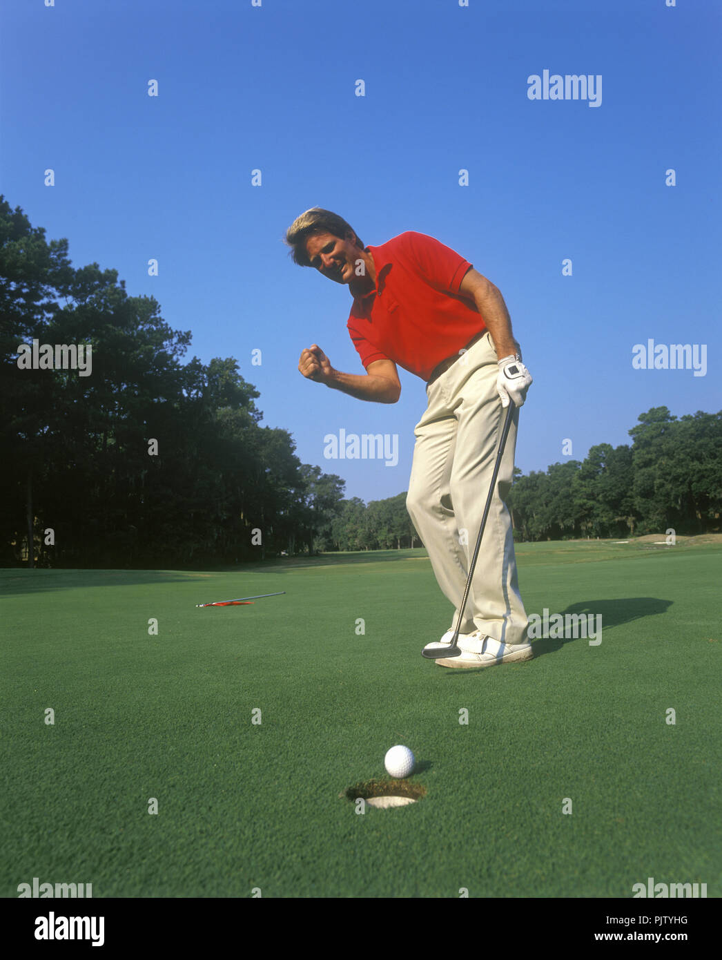 1990 L'uomo storico golfista dal foro sul putting green Foto Stock
