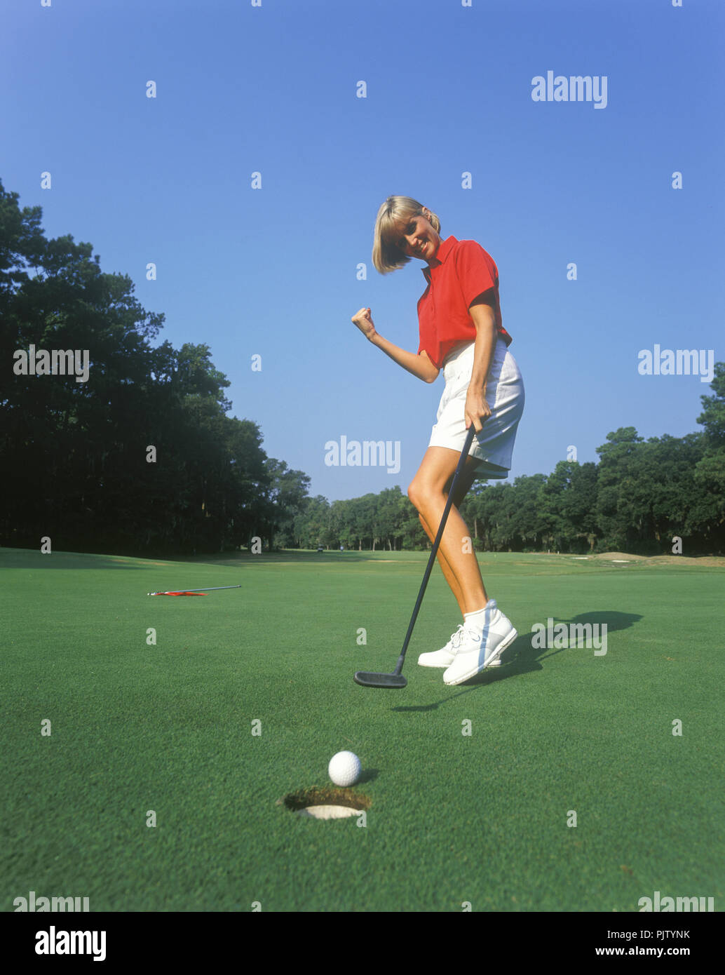 1990 Donna storico golfista dal foro sul putting green Foto Stock