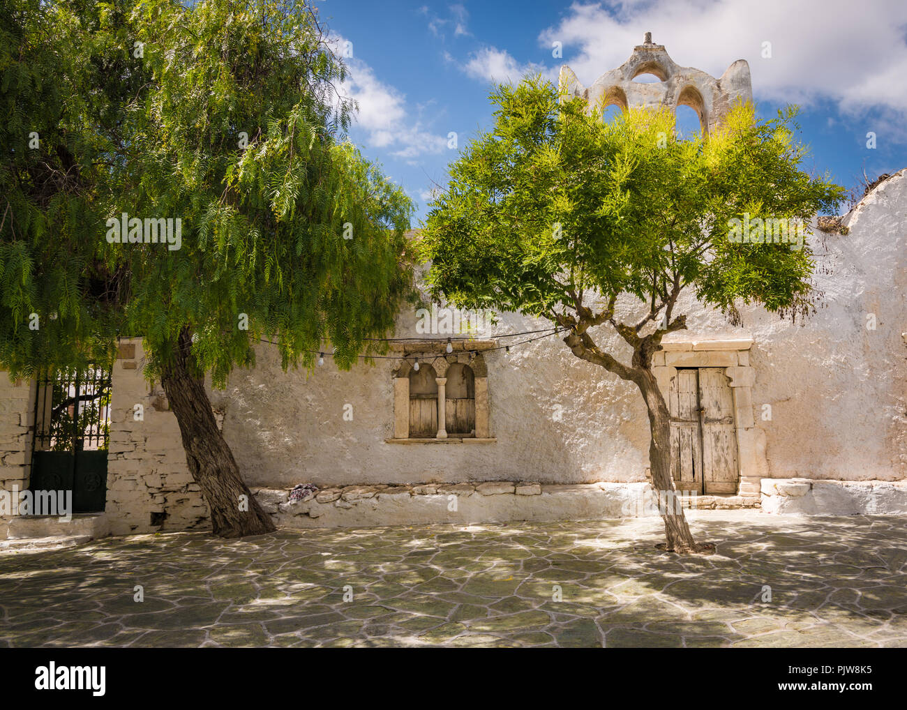 Piazza con la parte anteriore della vecchia chiesa e olivi Foto Stock