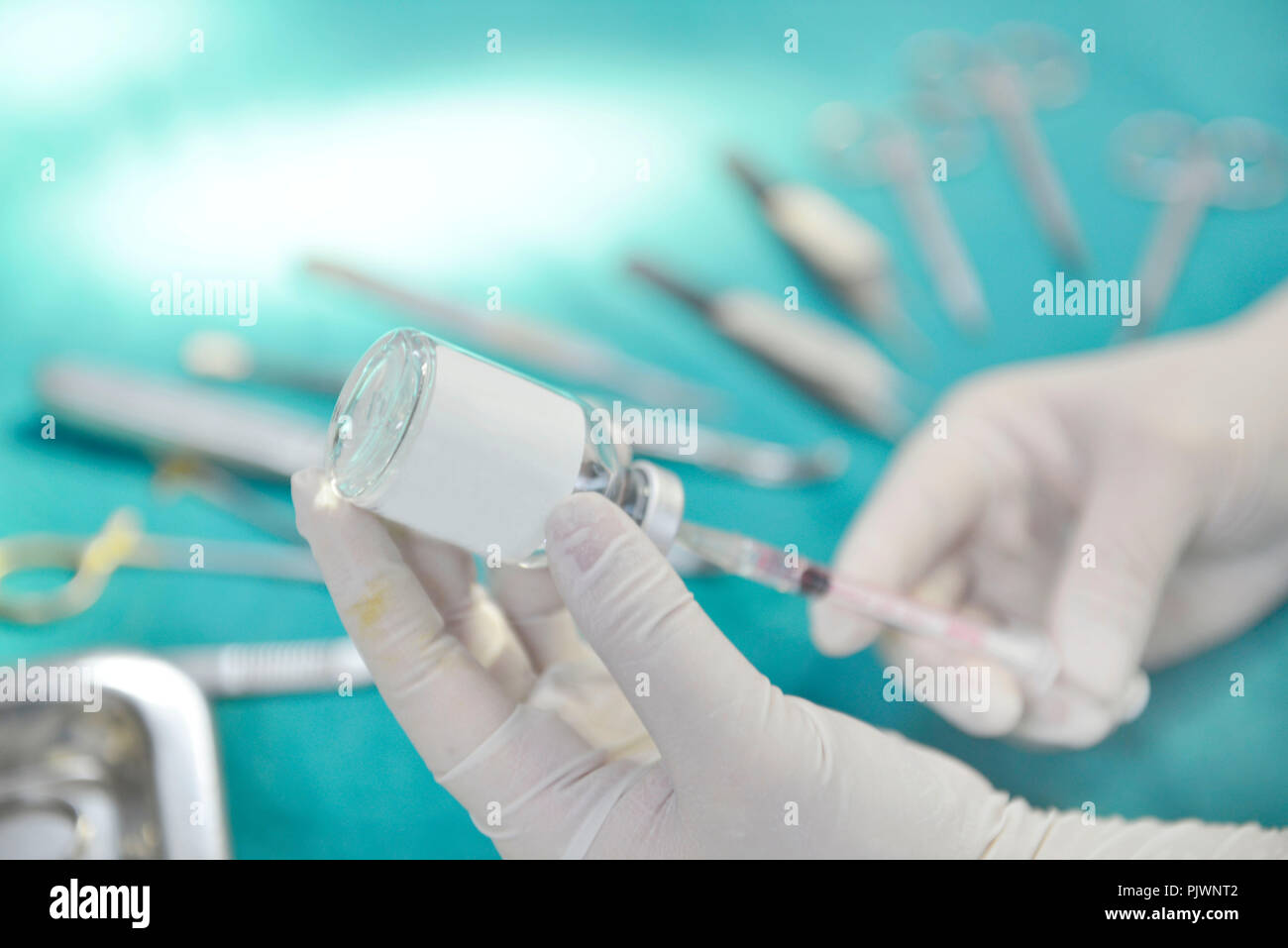 Mano che tiene la siringa e la medicina preparare flaconcino per iniezione con apparecchiature chirurgiche e medicina sfondo fiala Foto Stock