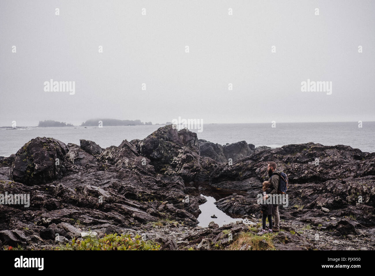 Padre e figlio camminando sulle rocce, Tofino, Canada Foto Stock