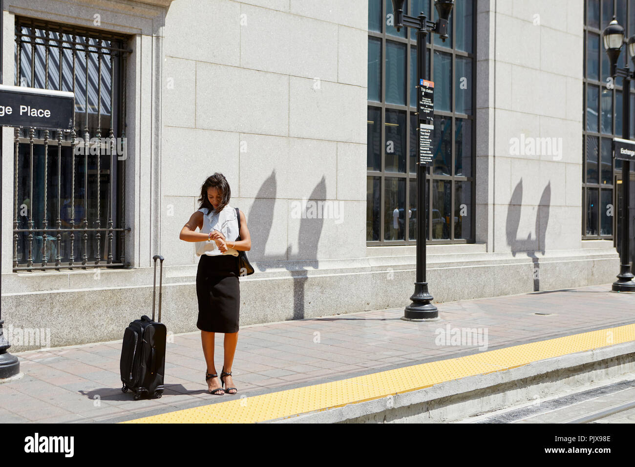 Imprenditrice tempo di controllo mediante linea light rail Foto Stock