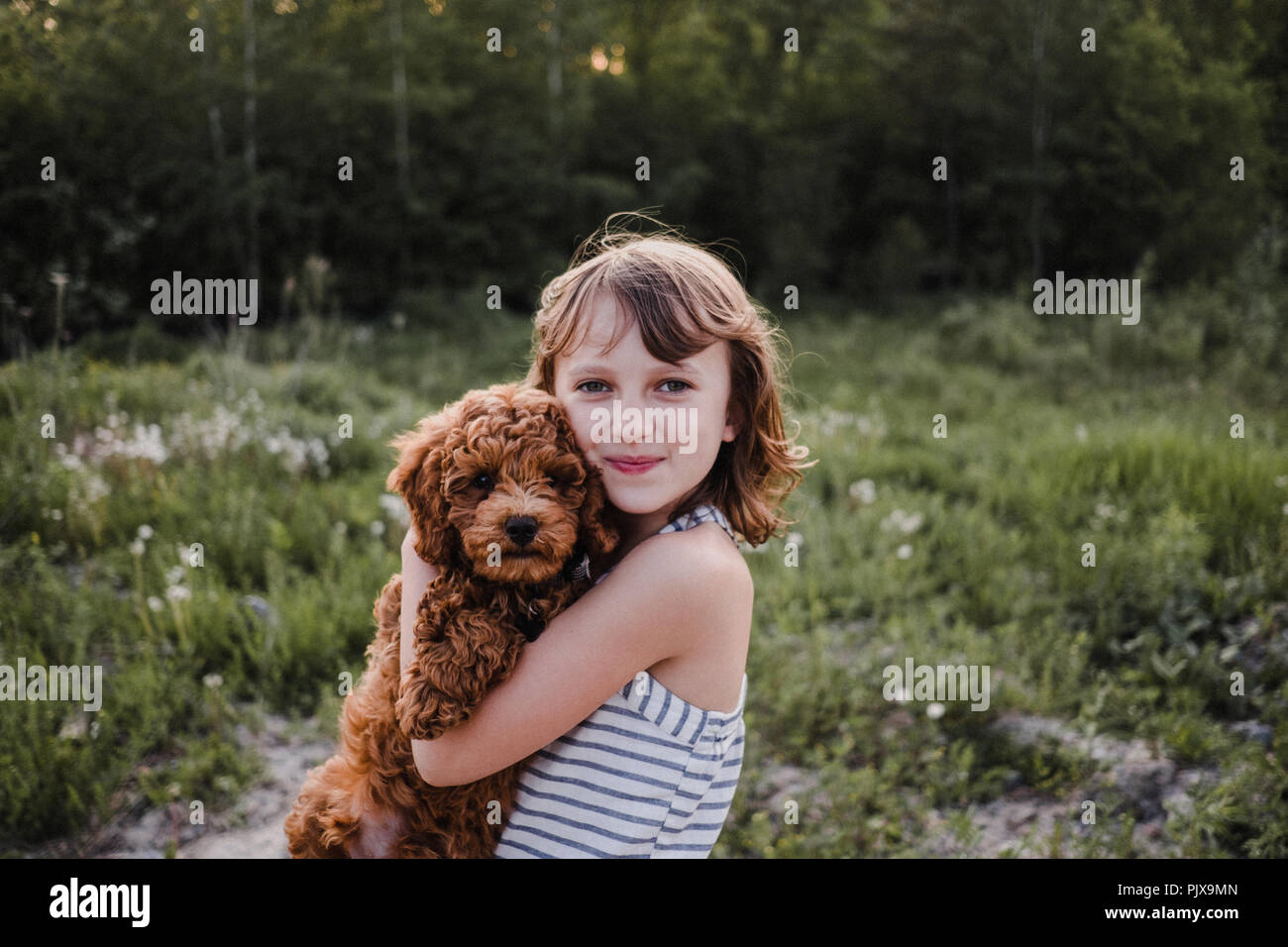 Ragazza in posa con cucciolo nelle sue braccia Foto Stock