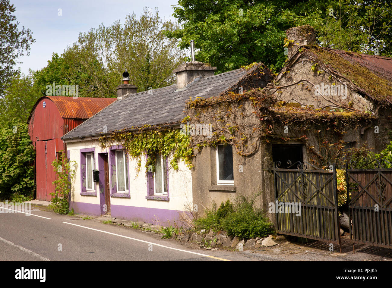 Irlanda, Co Leitrim, Manorhamilton, centro città, antico casolare e ferro corrugato barn Foto Stock