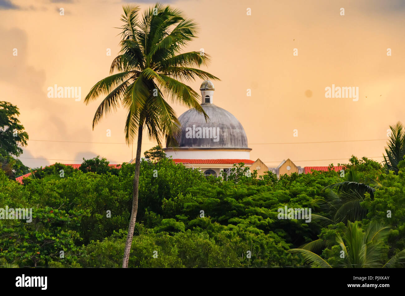 Sunset skyscape della Repubblica Dominicana con tetto e plam alberi Foto Stock
