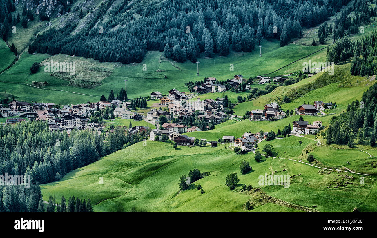 Piccolo paese di Colfosco sulle colline con prato verde nella stagione estiva, Alta Badia - Trentino Alto Adige, Italia Foto Stock