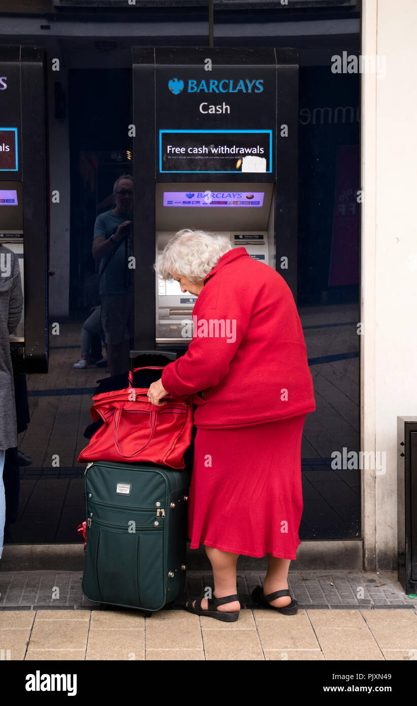 Signora anziana utilizzando un Barclays Bank bancomat, Bristol, Inghilterra, Regno Unito Foto Stock