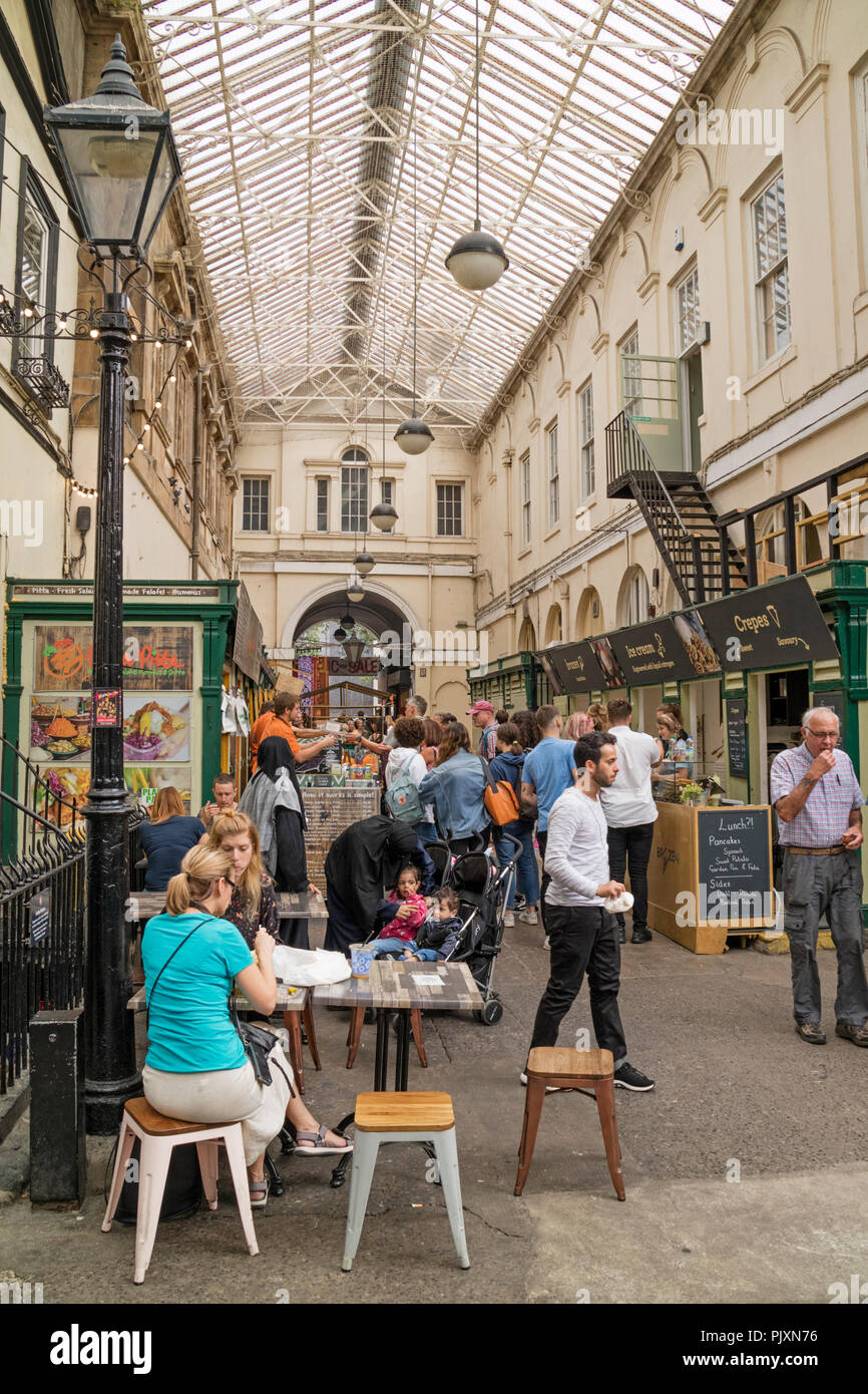 Persone mangiare presso il St Nicholas mercati, Bristol, Inghilterra, Regno Unito Foto Stock
