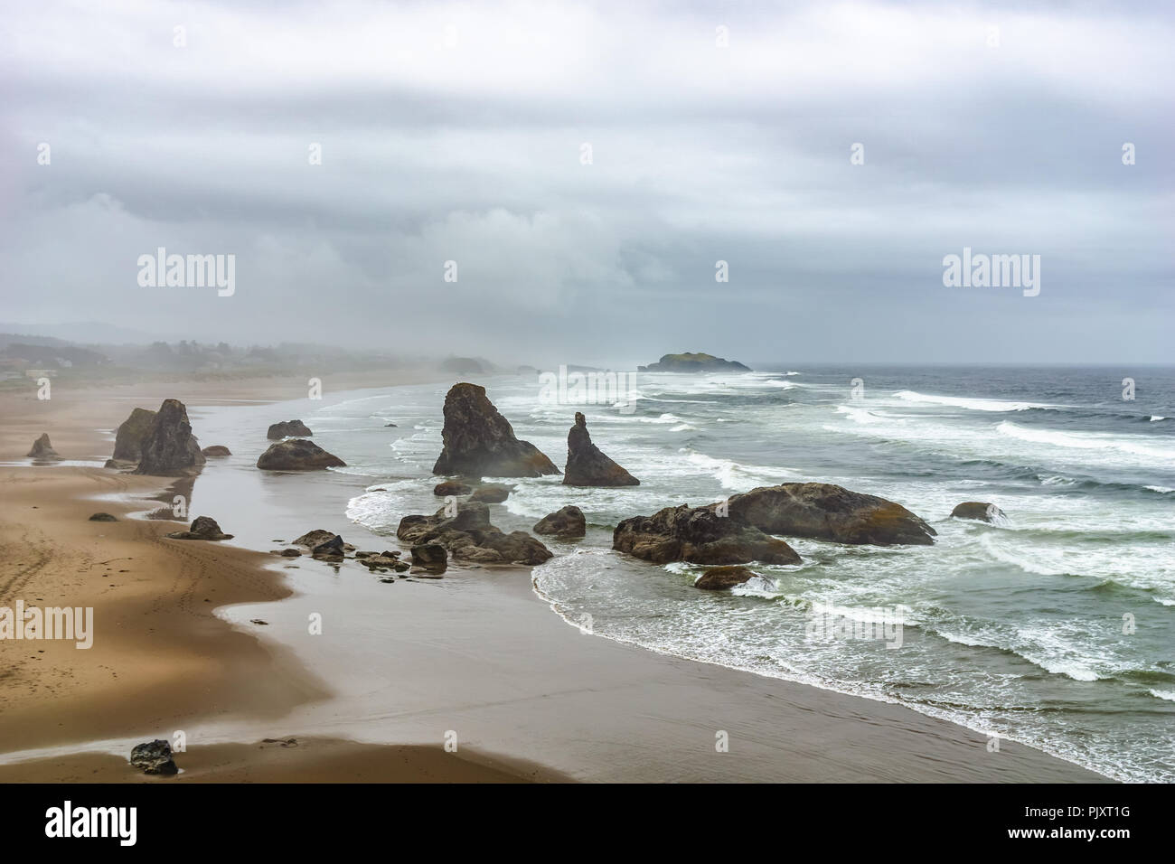 Bandon Beach si affacciano sul paesaggio con pile di mare o di affioramenti rocciosi lungo la costa su un nuvoloso giorno piovoso, Oregon Coast, Stati Uniti d'America. Foto Stock