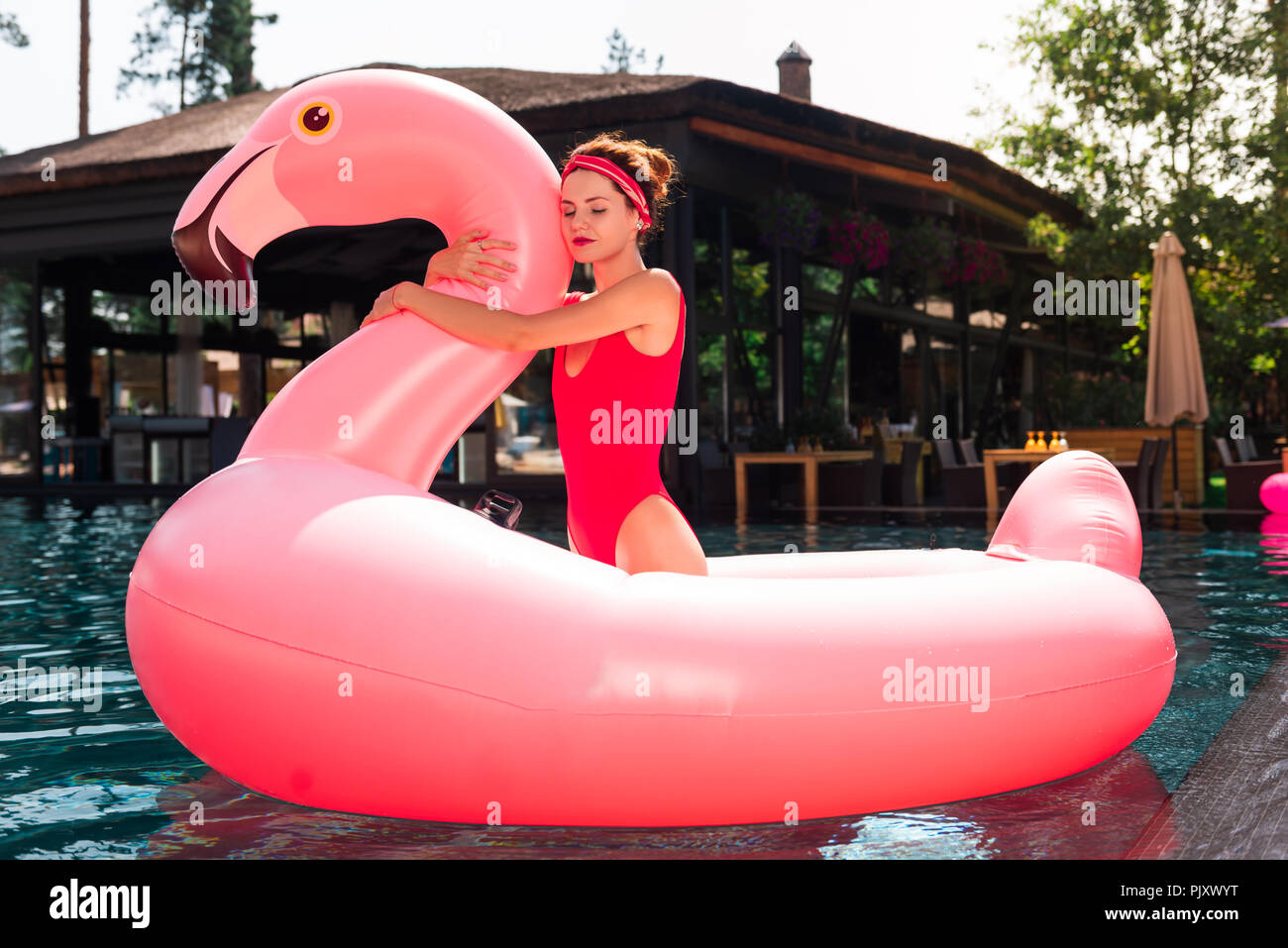 Positivo donna skinny abbracciando un aria flamingo Foto Stock