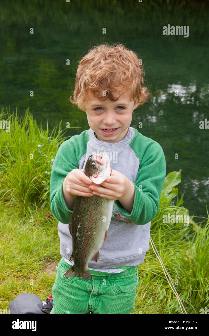 Ragazzo di quattro anni a Meon Springs Trout Fishery, East Meon, Hampshire, Inghilterra, Regno Unito. Foto Stock