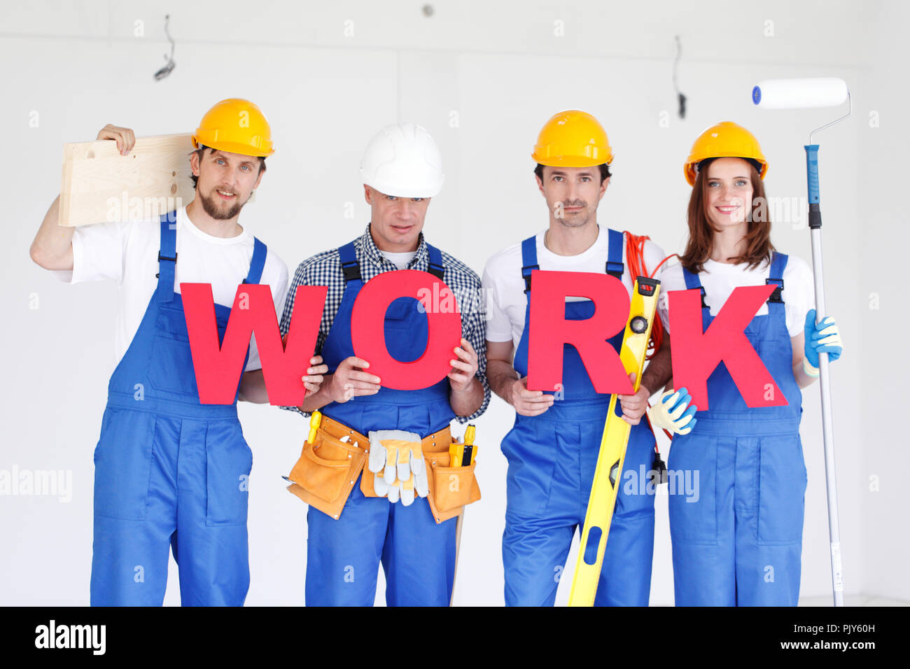 Un gruppo di operai con parola di lavoro e strumenti in ambienti interni Foto Stock