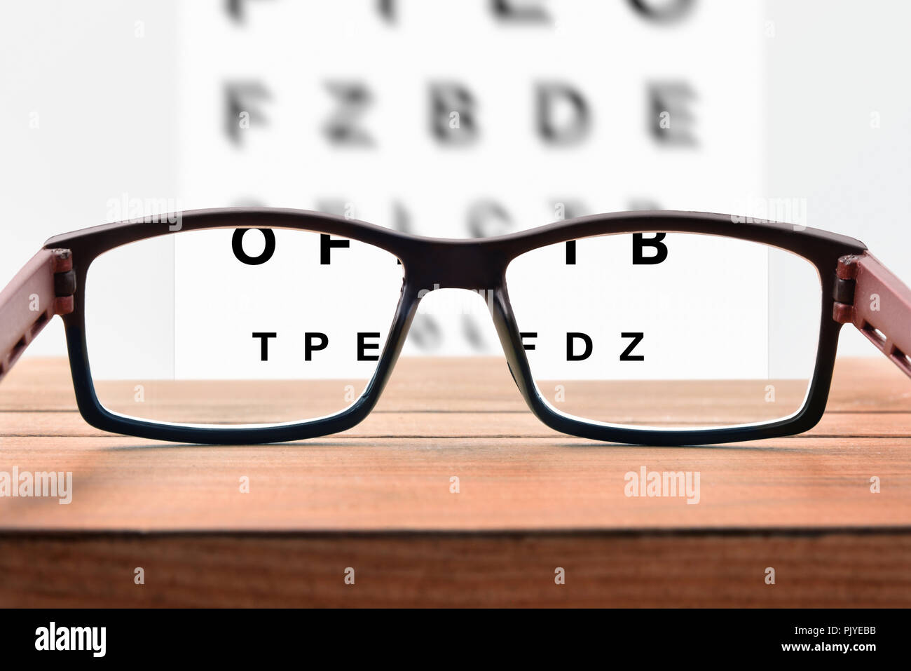 Concetto di revisione degli occhi con foglio con lettere e occhiali da vista. Vista frontale. Composizione orizzontale Foto Stock