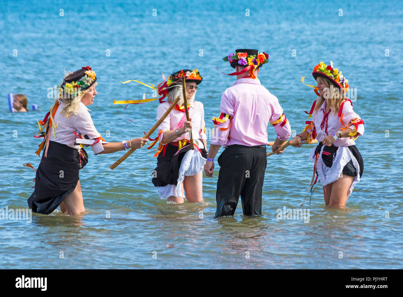 Swanage, Dorset, Regno Unito. Il 9 settembre 2018. La folla gregge al 2° giorno di Swanage Folk Festival per vedere i gruppi di danza e musica lungo il lungomare. Delizioso caldo clima soleggiato sedotto alcuni ballerini di danza in mare al termine di un weekend meraviglioso. Morris ballerini, membri di Phoenix Morris dancing in mare. Credito: Carolyn Jenkins/Alamy Live News Foto Stock