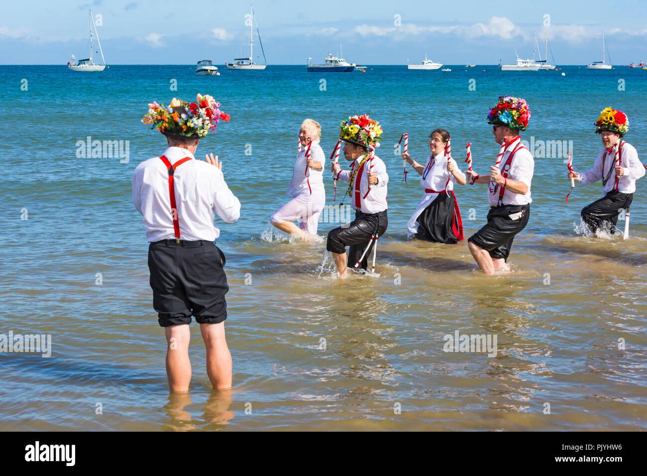 Swanage, Dorset, Regno Unito. Il 9 settembre 2018. La folla gregge al 2° giorno di Swanage Folk Festival per vedere i gruppi di danza e musica lungo il lungomare. Delizioso caldo clima soleggiato sedotto alcuni ballerini di danza in mare al termine di un weekend meraviglioso. Morris ballerini, membri di Basingclog Morris dancing in mare. Credito: Carolyn Jenkins/Alamy Live News Foto Stock