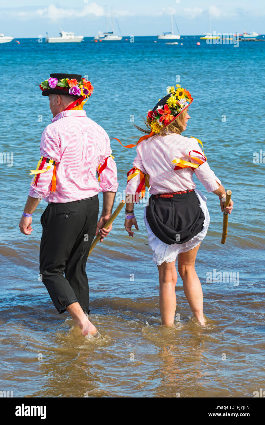 Swanage, Dorset, Regno Unito. Il 9 settembre 2018. La folla gregge al 2° giorno di Swanage Folk Festival per vedere i gruppi di danza e musica lungo il lungomare. Delizioso caldo clima soleggiato sedotto alcuni ballerini di danza in mare al termine di un weekend meraviglioso. Morris ballerini, membri di Phoenix Morris dancing in mare. Credito: Carolyn Jenkins/Alamy Live News Foto Stock