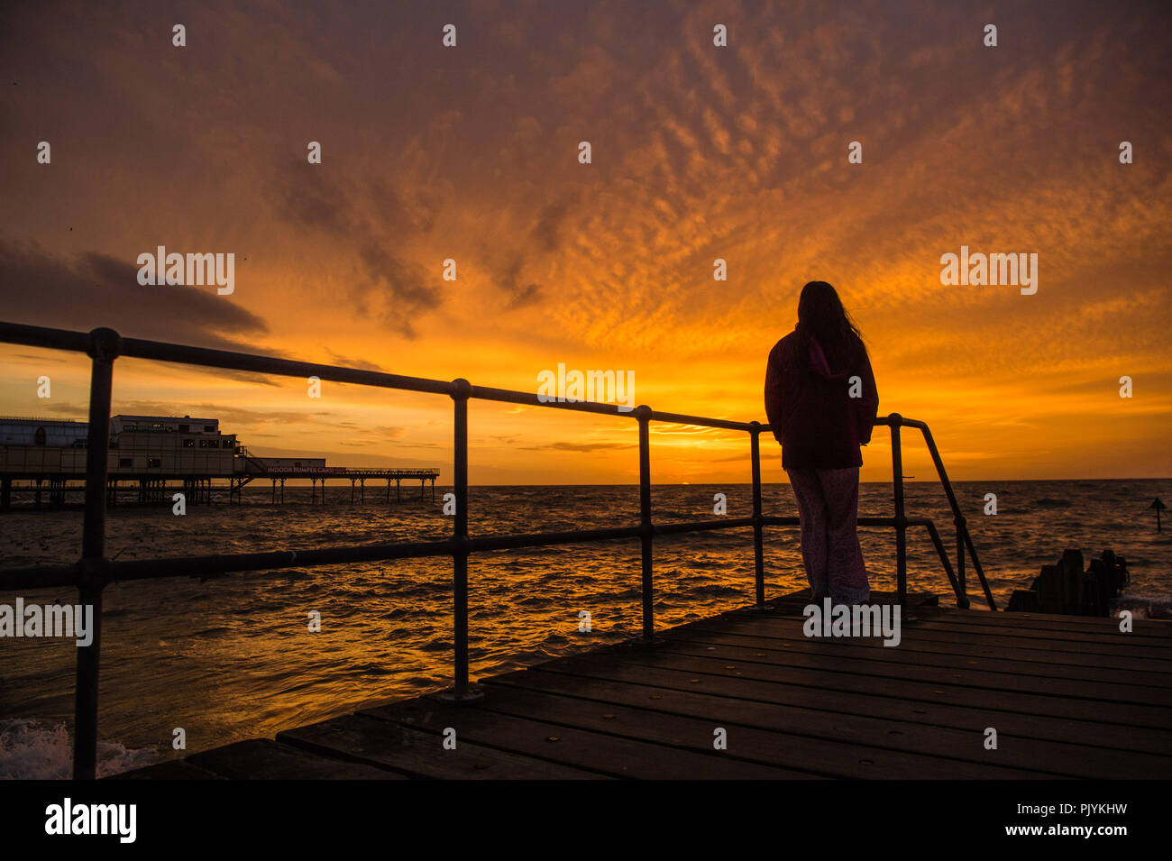 Aberystwyth Wales UK, domenica 09 settembre 2018 UK Meteo: una donna orologi il tramonto come alta marea e forti venti si combinano per portare enormi onde che si schiantano nella passeggiata a mare e la parete in Aberystwyth, il Cardigan Bay costa del Galles occidentale. Il Meteo previsioni è di diventare più instabile nei prossimi giorni, con il vento e la pioggia che colpiscono molti settentrionali e occidentali della zone Foto © Keith Morris / Alamy Live News Foto Stock
