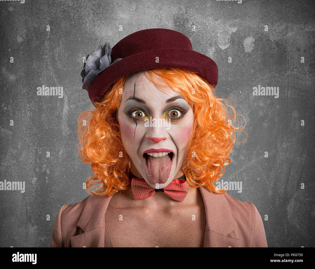 Funny Grimace clown ragazza ragazza con la lingua fuori Foto Stock